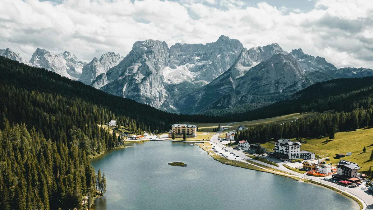 Lake Misurina below grey limestone peaks, with the village spread along its far shore
