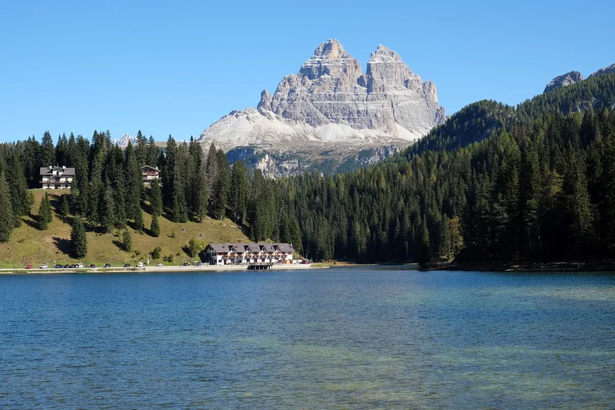 Tre Cime di Lavaredo rising above the forest on the far shore of Lake Misurina